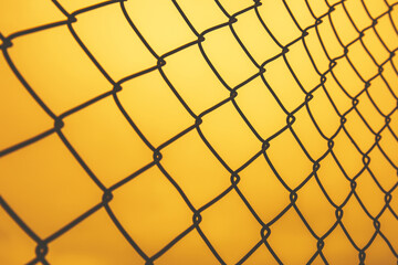Fototapeta premium Iron or metal net fence at sunset or evening time.