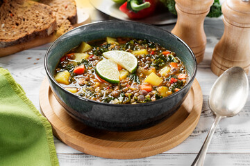 Green lentil soup with vegetables and green kale salad leaves. Vegetarian food.
