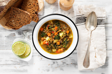 Green lentil soup with vegetables and green kale salad leaves. Vegetarian food. top view - obrazy, fototapety, plakaty