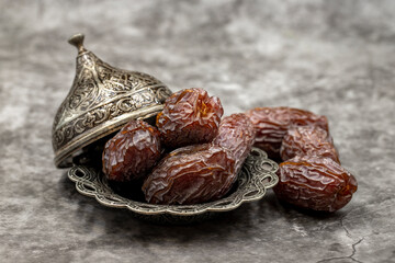 Date fruit on a dark background. Date fruits on a rustic serving plate