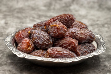 Date fruit on a dark background. Date fruits on a rustic serving plate