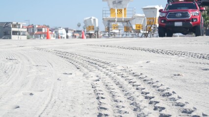 Lifeguard pickup truck, life guard station or hut, California ocean beach USA. Rescue pick up auto car for surfing safety, tire track or wheel imprint of lifesavers 911 vehicle on sand, Mission beach. © Dogora Sun