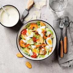 Fresh Shrimp Caesar Salad with parmesan cheese and Croutons. Gray background, top view