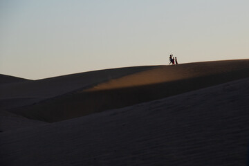 Fototapeta na wymiar silhouette of people in the dunes