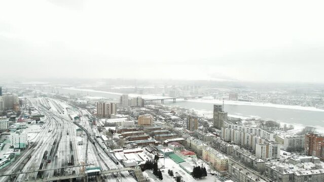Aerial survey of a winter city in the snowfall. Urban industrial landscape.