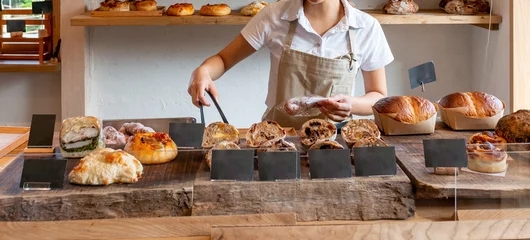 Schilderijen op glas パン屋　ベーカリーショップ　トングで焼きたてパンを掴むエプロン姿の女性店員 © Metro Hopper