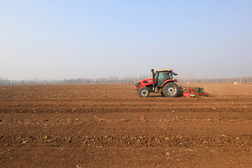 Farmers drive planters to plant peas in the fields, North China