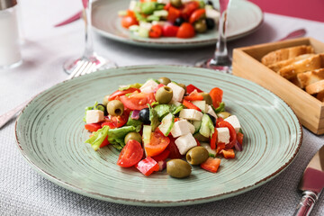 Plate with healthy Greek salad on table in restaurant