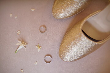 two wedding rings and expensive shoes on a white background