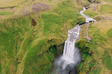 Fototapeta na wymiar Skogafoss waterfall with river above in summer. Birds eye view from drone. Iceland.