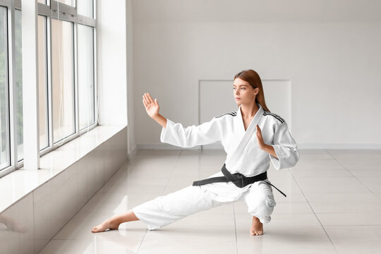 Young woman practicing karate in gym