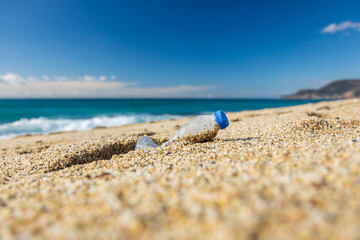 Fototapeta na wymiar Garbage pollution of the planet. Empty plastic bottle on the beach sand. Consequences of human life