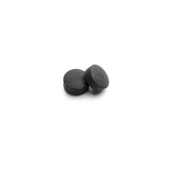 Two activated carbon pills on white background