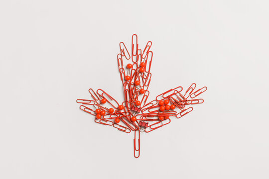 Maple leaf made of paper clips on light background. Canadian flag concept