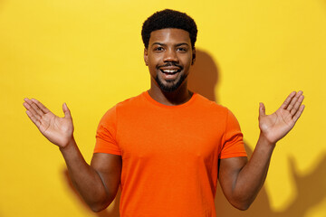 Young surprised satisfied impressed fun man of African American ethnicity 20s in orange t-shirt...