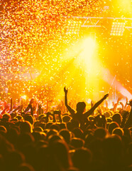 A crowded concert hall with scene stage orange and yellow lights, rock show performance, with...
