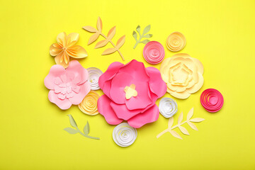 Beautiful handmade paper flowers on yellow background