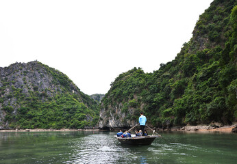 Fototapeta na wymiar Locals taking tourists on a boat for sightseeing in Lan Ha Bay, Ha Long, Vietnam