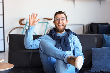 Happy young man video chatting at home