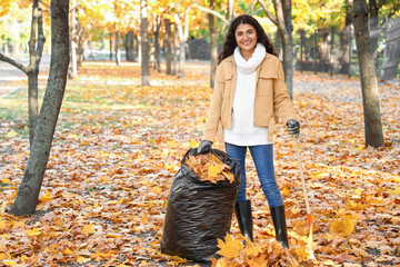 Woman gathering autumn leaves outdoors