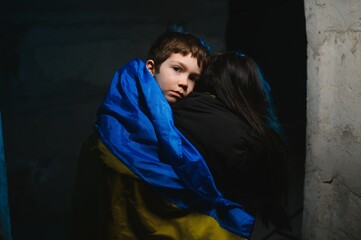 Loving mother holding her child in the bomb shelter. The war in Ukraine. Russia's aggression.