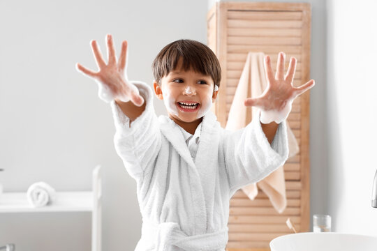 Cute little boy washing hands in bathroom
