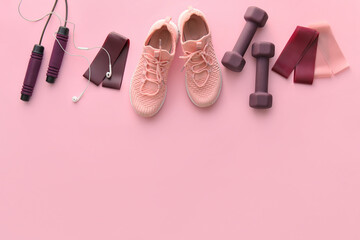Set of sports equipment with shoes and earphones on color background