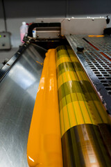 Color and glossy rollers of offset printing machine. offset ink colour.  yellow. Photo taken horizontally, selected focus cylinder middle.