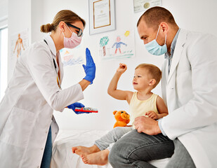 Obraz premium child doctor hospital patient medical nurse medicine health woman boy mask corona virus epidemic care healthcare pediatrician stethoscope clinic toy man