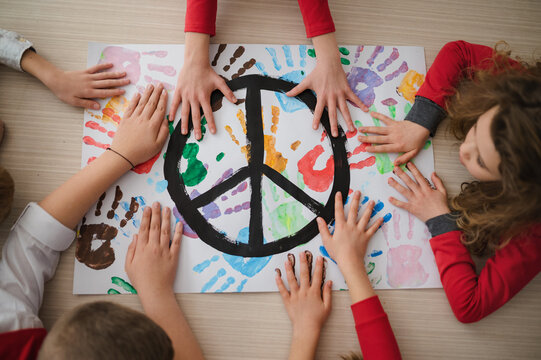 Top view of children making a poster of peace sign at school.