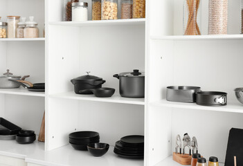Shelf unit with set of clean dishes in kitchen