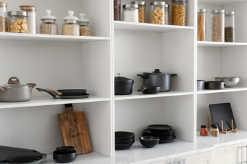 Shelf unit with set of clean dishes in kitchen