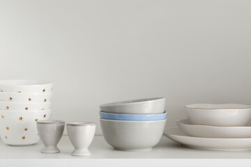 Fototapeta na wymiar Shelf with set of clean dishes in kitchen
