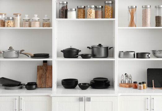 Shelf unit with set of clean dishes in kitchen