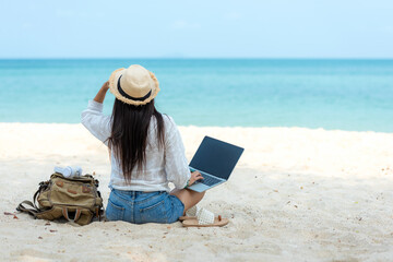 Lifestyle freelance woman  using laptop working and relax on the beach. Asian people success and together your work pastime and meeting conference on internet in holiday. Business and Summer Concept - obrazy, fototapety, plakaty