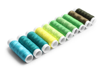 Multicolored sewing thread spools on white background
