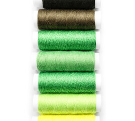 Multicolored sewing thread spools on white background