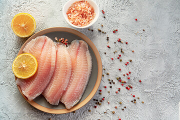 Tilapia fish fillet with spices and lemon. Healthy food rich in proteins.