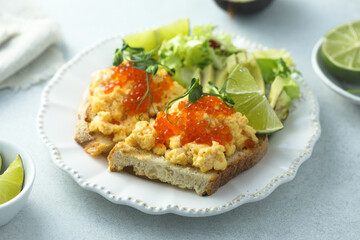 Scrambled eggs with red caviar on toast