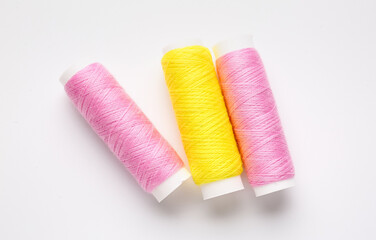 Different thread spools on white background