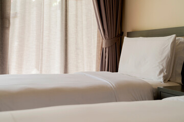 Bed maid-up with clean white pillows and bed sheets in beauty room. Close-up. Lens flair in...