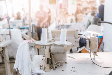Concept Interior of garment factory. Closeup spool of multicolored threads for sewing machine