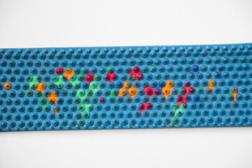 Top view of a medical lyapko rubber mat with sharp small needles on a white surface