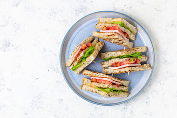 sandwich with ham cheese tomatoes lettuce onions on plate. Classic club sandwich with whole grain bread