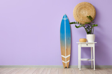 Interior of room with surfboard and table near color wall