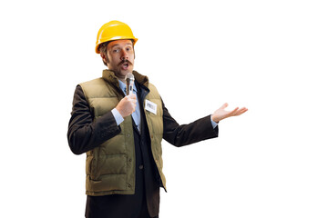 Portrait of young man in helmet, professional commentator, journalist with microphone broadcasting isolated over white background. News, emotions, job concept