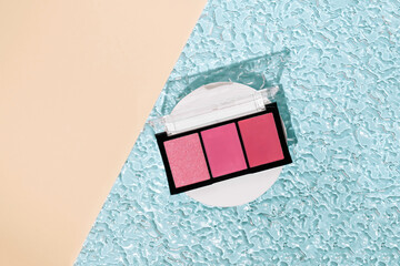 Modern minimal summer makeup concept with pink shades of eye shadows on blue beach water. Trendy...