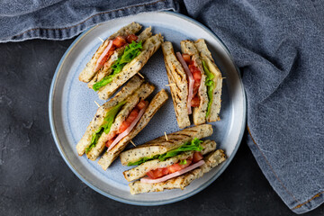 sandwich with ham cheese tomatoes lettuce onions on plate. Classic club sandwich with whole grain bread