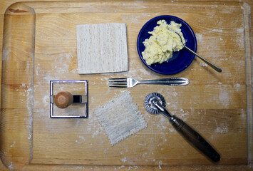 Making home made revioli overhead of tools and ricotta cheese.