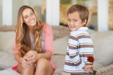 Mommys little champ. Shot of a mother holding a flower her son gave hr for Mothers day.